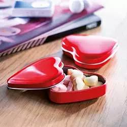 porta caramelle a forma di cuore rosso su scrivania per gadget matrimonio